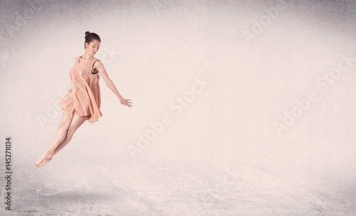 Modern ballet dancer performing art jump with empty background