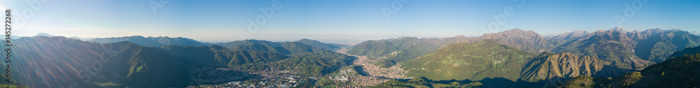 4K Drone aerial view to the Seriana valley and Orobie Alps in a clear and blue day. View of the highest mountains including Arera. Panorama from Farno Mountain, Bergamo, Italy. 