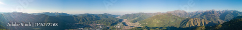 4K Drone aerial view to the Seriana valley and Orobie Alps in a clear and blue day. View of the highest mountains including Arera. Panorama from Farno Mountain  Bergamo  Italy. 