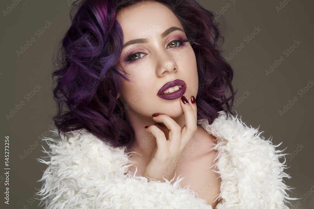 Portrait of young beautiful woman with violet make up and purple hair. Beauty concept.