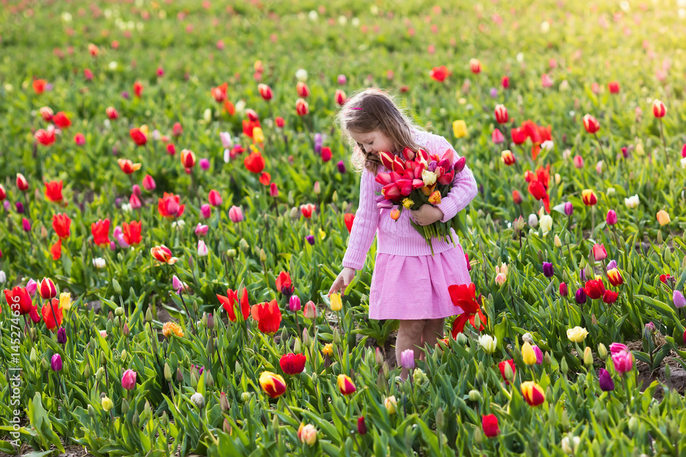 Little girl in tulip flower garden Little girl in tulip flower garden