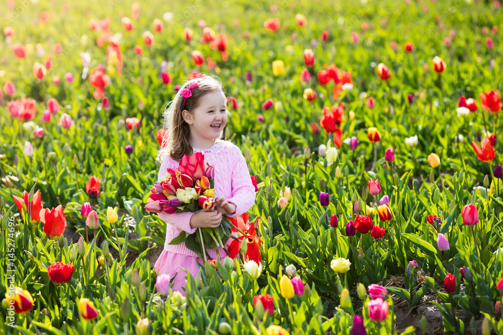 Little girl in tulip flower garden Little girl in tulip flower garden