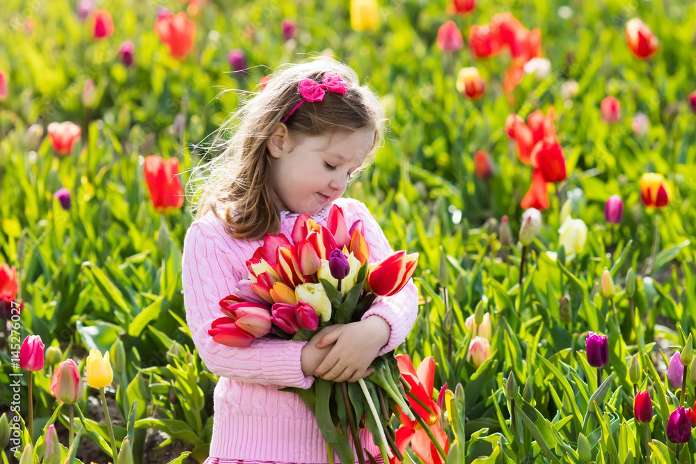 Little girl in tulip flower garden Little girl in tulip flower garden