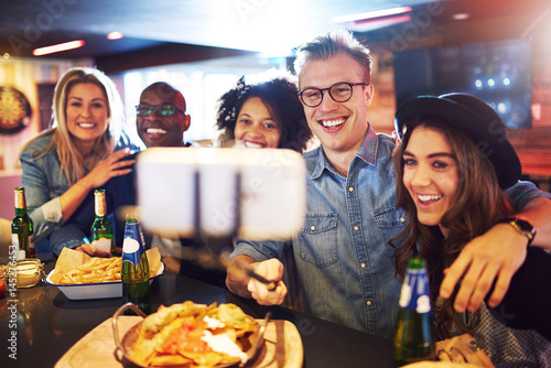 Happy group of people selfies in bar