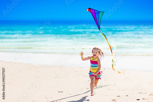 Child flying kite on tropical beach