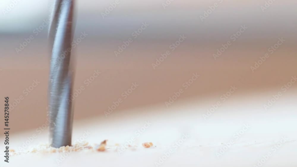 Electric drill drills a piece of wood closeup Electric drill drills a piece of wood closeup