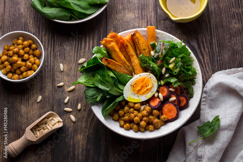 Lunch bowl with sweet potatoes, chickpeas, spinach, carrots and boiled egg