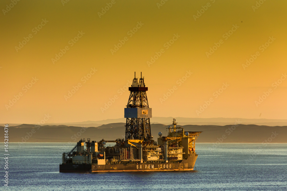 The Drill ship Saipem 1200 waits quietly of the coast of west Africa waiting for the oil downturn  to reverse and price of oil returns to profitable prices .