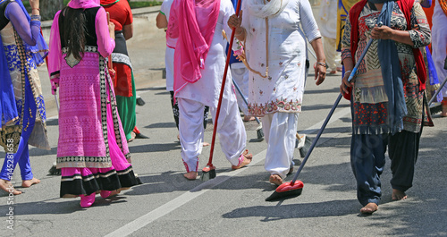 Sikh women while scavenging the street with a broom during a fes