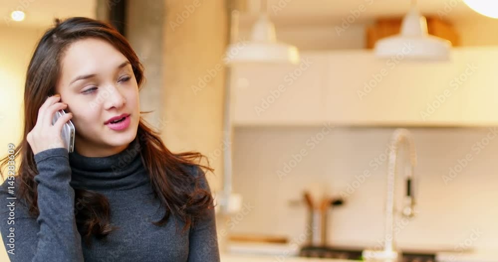 Woman talking on mobile phone in living room Woman talking on mobile phone in living room
