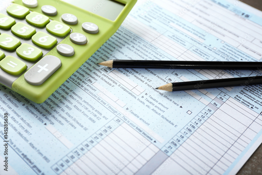 Green calculator with documents on table. Tax concept Green calculator with documents on table. Tax concept
