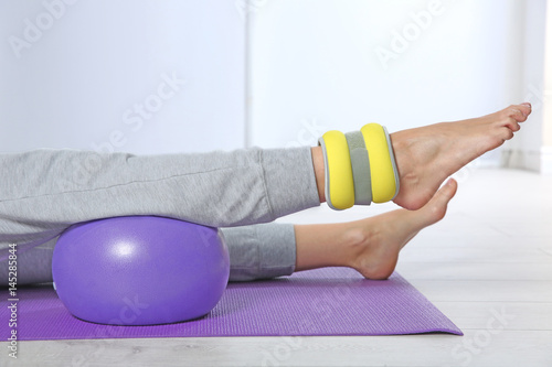 Woman training with weight on leg in gym