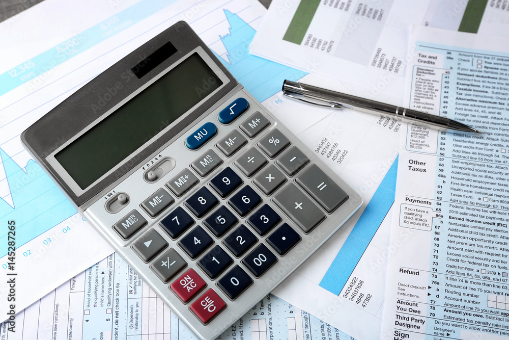 Calculator with documents and pen on table. Tax concept Calculator with documents and pen on table. Tax concept
