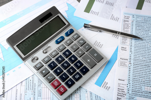 Calculator with documents and pen on table. Tax concept