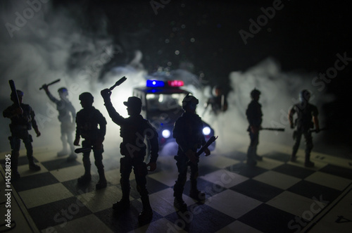 Anti-riot police give signal to be ready. Government power concept. Police on chessboard. Smoke on a dark background with lights. Blue red flashing sirens