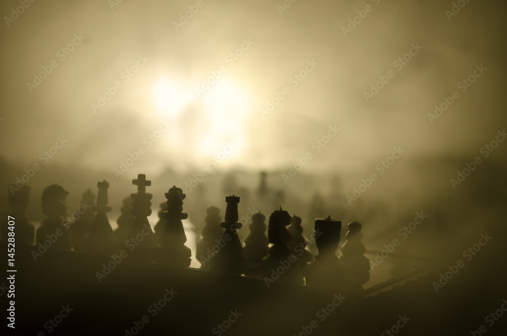 Fototapeta premium chess board game concept of business ideas and competition and strategy ideas concep. Chess figures on a dark background with smoke and fog.