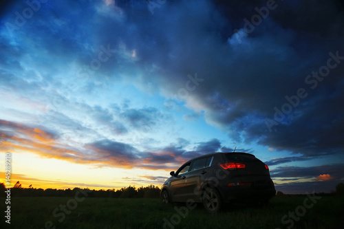 Car in the field at sunset