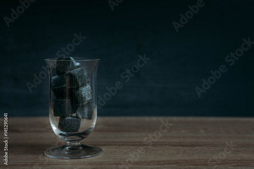 Stones for cooling whiskey and glases tulup on dark wooden background photo