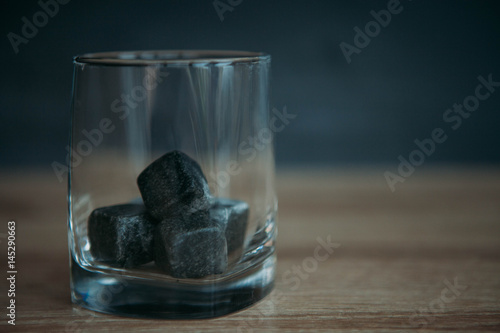 Stones for cooling whiskey and glases tumbler on dark wooden background photo