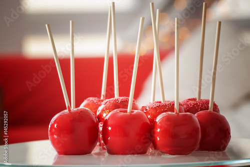 Delicious holiday apples on glass table against blurred background photo