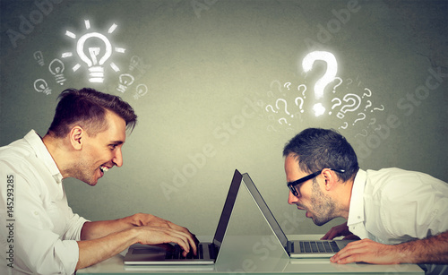 Two men using laptop computer one educated has bright ideas the other ignorant has questions photo