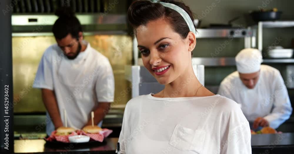 Happy waitress standing in kitchen Happy waitress standing in kitchen