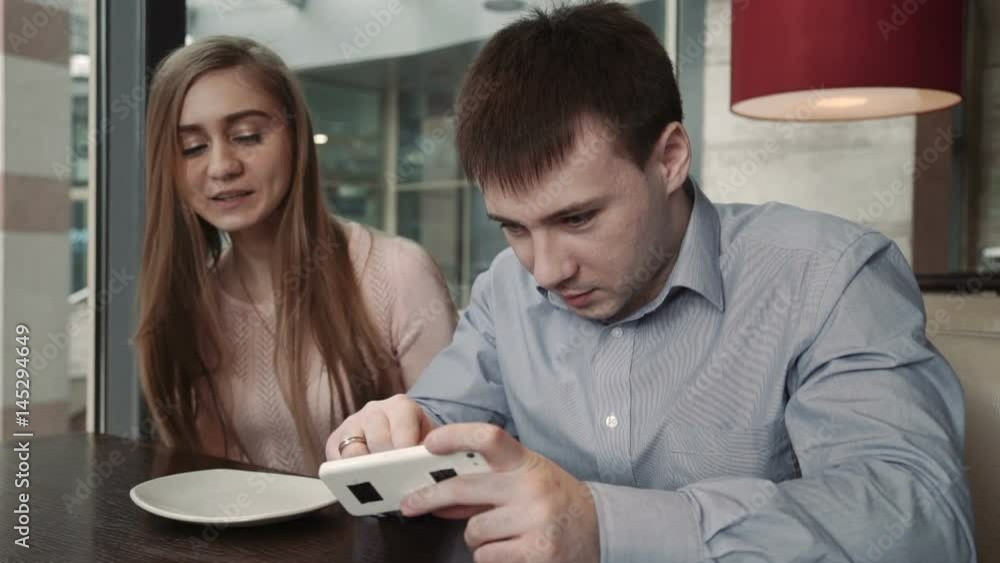 Attractive young couple using smartphone at cafe Look at the display smiling Attractive young couple using smartphone at cafe Look at the display smiling