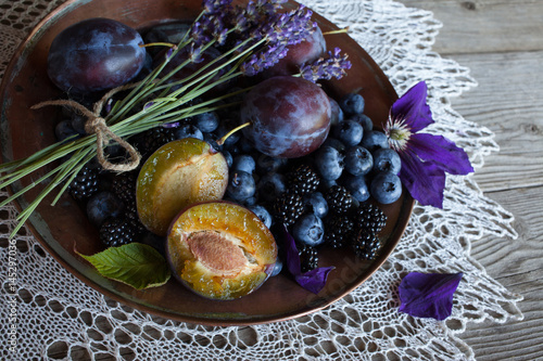 Plums, blueberries and blackberries in a bowl on the table