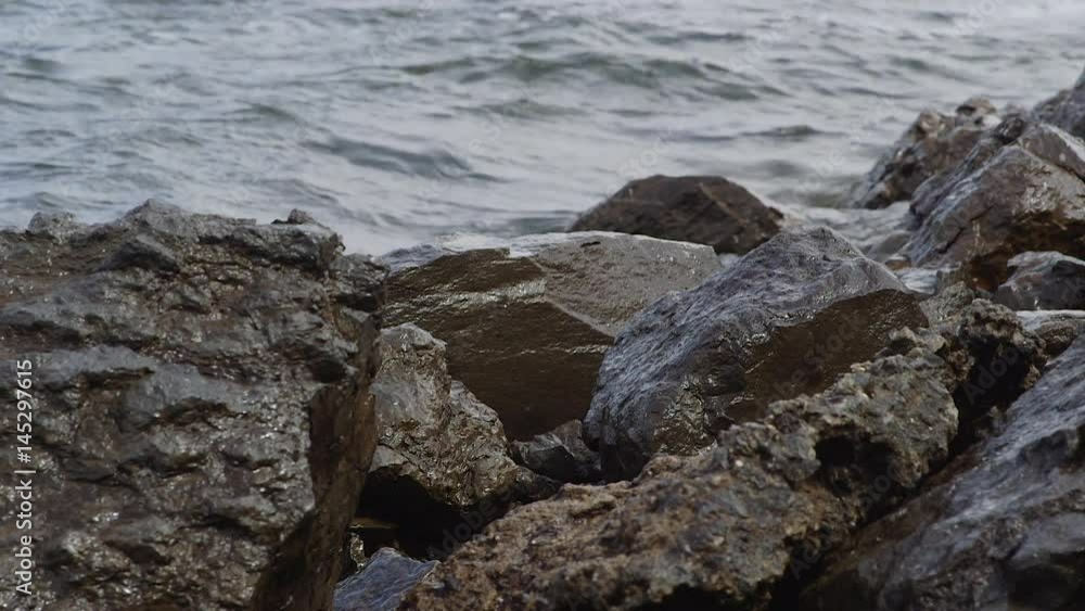 Waves Crashing on Rocks Near Lake During Cloudy Summer Day Waves Crashing on Rocks Near Lake During Cloudy Summer Day