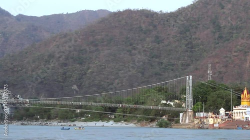 A shot of the Rishikesh Valley and Lakshman Jhula iron suspension bridge across the River Ganges in the holy city of Rishikesh, India. photo