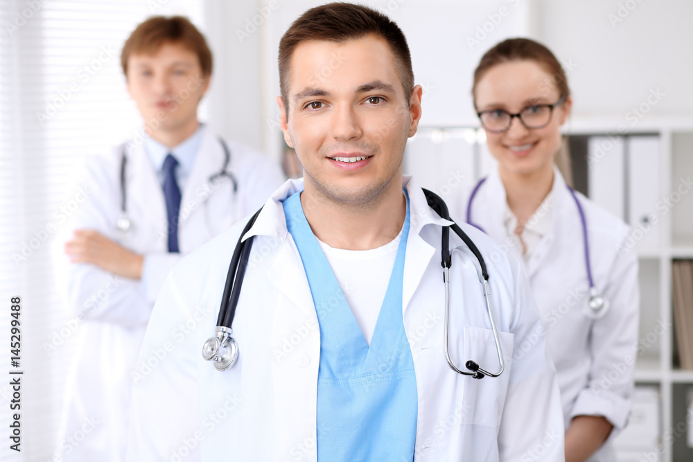 Cheerful smiling male doctor with medical staff at the hospital Cheerful smiling male doctor with medical staff at the hospital