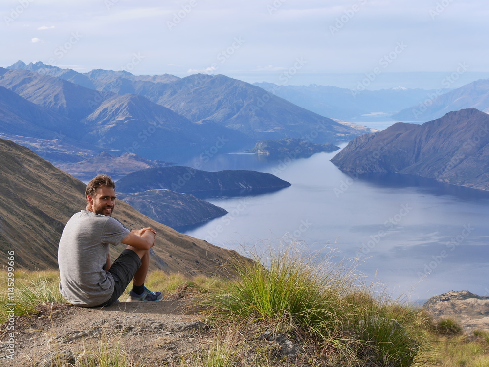Young man in front of mountain and lake landscape