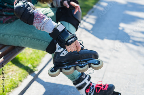 Roller girl unscrewing wheels on freeskate roller Skates with Allen key or Hex key tool. Maintenance of professional skates photo