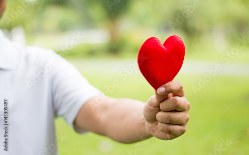 Fototapeta Naklejka Na Ścianę i Meble -  a man holding a red heart