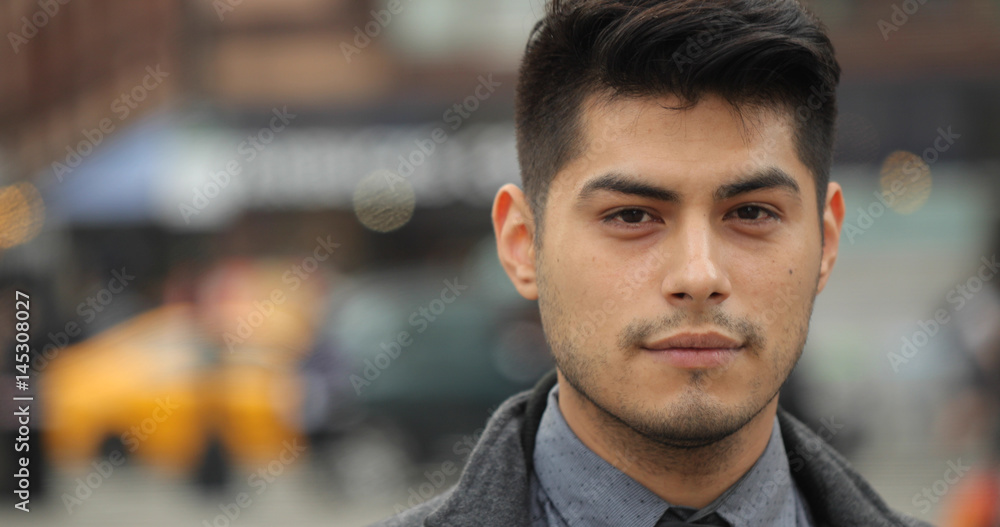 Young Hispanic Latino man in city face portrait