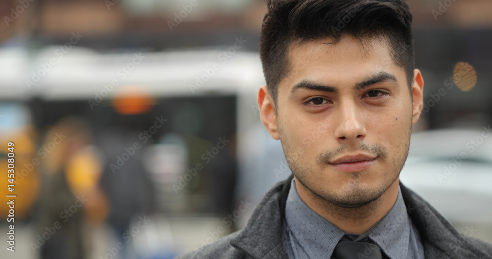 Young Hispanic Latino man in city face portrait Young Hispanic Latino man in city face portrait