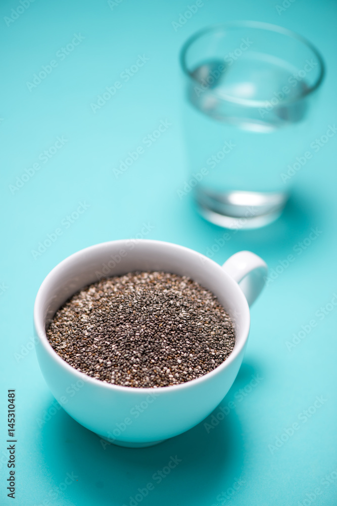 Glass of water and healthy chia seeds in a cup. Text space. Glass of water and healthy chia seeds in a cup. Text space.