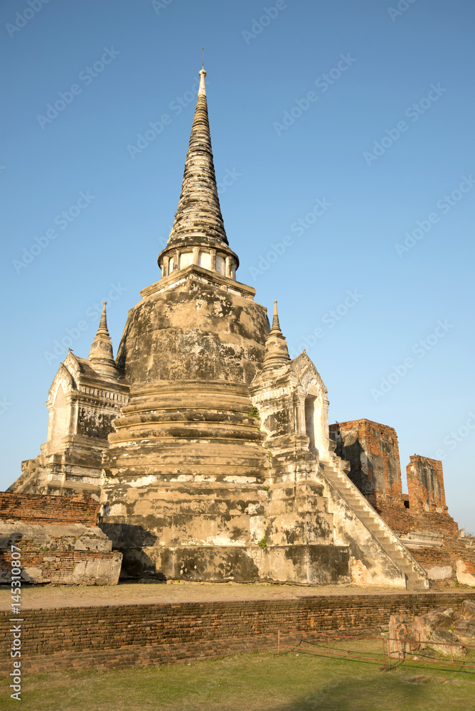 Fototapeta premium One of the three ancient stupas of the Buddhist temple Wat Phra Si Sanphet in the rays of the setting sun. Ayutthaya, Thailand