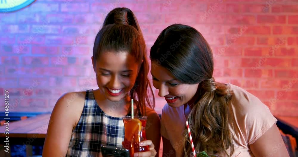 Friends taking selfie on mobile phone while having cocktail Friends taking selfie on mobile phone while having cocktail
