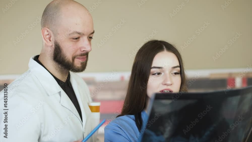 Medical team looking at x-ray together at hospital discuss 4k Medical team looking at x-ray together at hospital discuss 4k