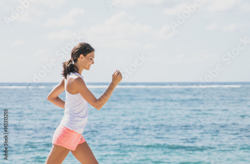 sporty woman jogging with skies and sea at the background