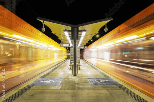 Gold Coast Trams passing each side of the station at night