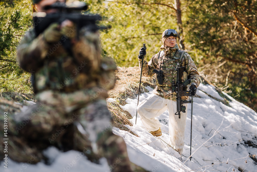 Fototapeta premium team of special forces weapons in cold forest. Winter warfare and military concept