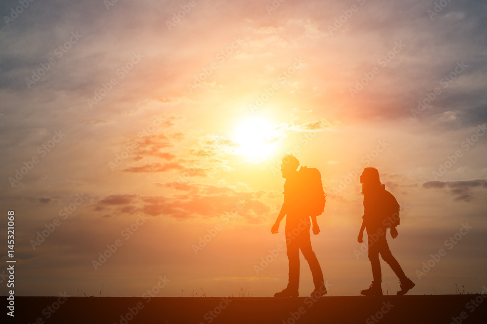 Silhouettes of two hikers with backpacks enjoying sunset. Travel concept. Silhouettes of two hikers with backpacks enjoying sunset. Travel concept.