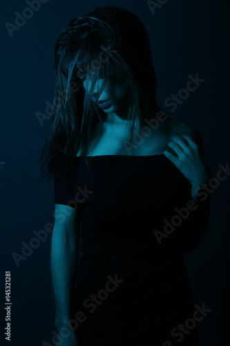 Beautiful woman wearing a black dress in a nightclub