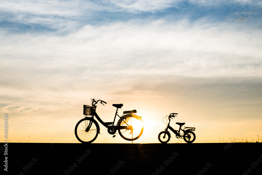 Two Silhouette vintage bicycle at sunset.