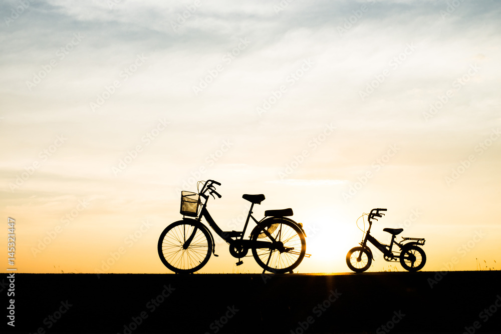 Obraz premium Two Silhouette vintage bicycle at sunset.