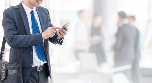 Business man using smart phone in office space background and copy space.