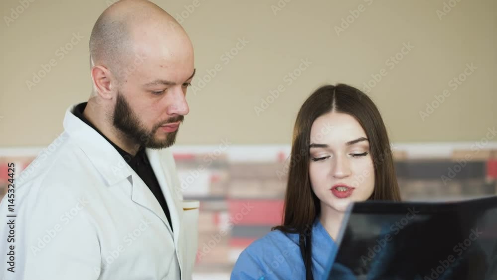 Medical team looking at x-ray together at hospital discuss 4k Medical team looking at x-ray together at hospital discuss 4k