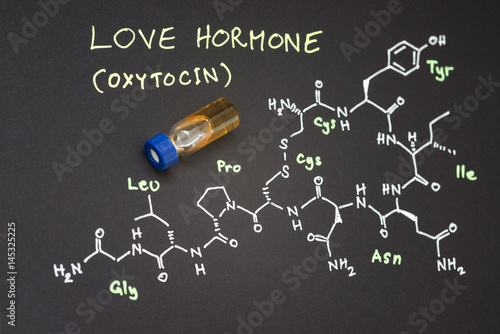 Close-up blue cap sample vial on paper with chemical formula of Oxytocin (love hormone)